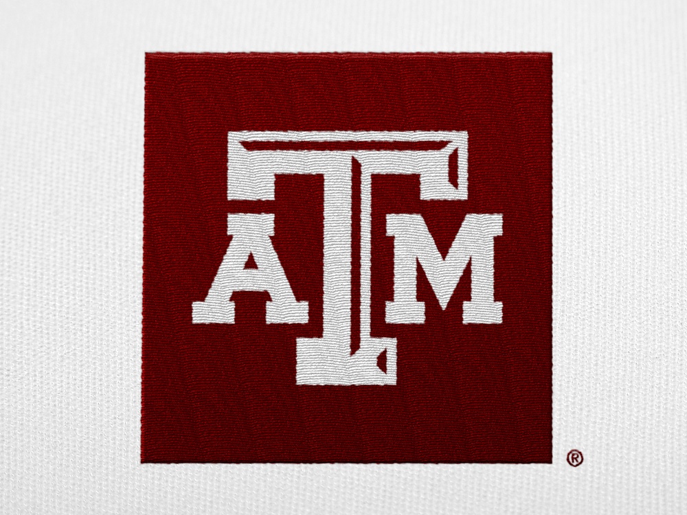 A white A&amp;M logo with a maroon box embroidered on a white shirt